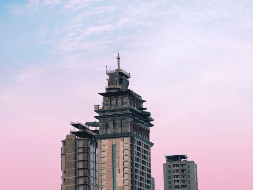 Crown Regency Hotel & Towers near Fuente Osmeña in Cebu City, showing the high-rise building with its rooftop spire against a pastel sky.
